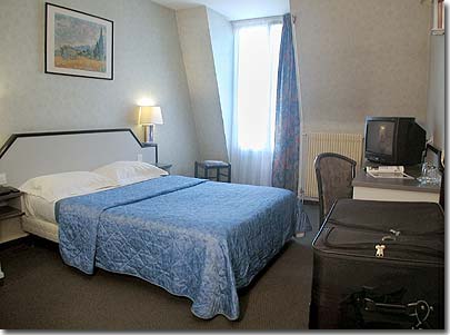Photo 5 - Hotel Trinite Plaza París 3* estrellas cerca del barrio Montmartre y del Sagrado Corazón (Basílica del Sacré Cœur) - Integramente renovadas, tranquilas e insonorizadas, nuestras habitaciones tienen una decoración que mezcla armoniosamente el encanto parisino y bienestar de la modernidad. Todas ellas disponen de ventanas con doble cristal, cuarto de baño con bañera o ducha, WC privados, secador de pelo, teléfono con línea directa y despertador automático, mini-bar, televisión de color por satélite y caja fuerte individual. Todas las habitaciones simples tienen una cama de matrimonio.